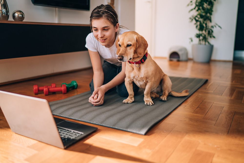 a girl and dog on mat