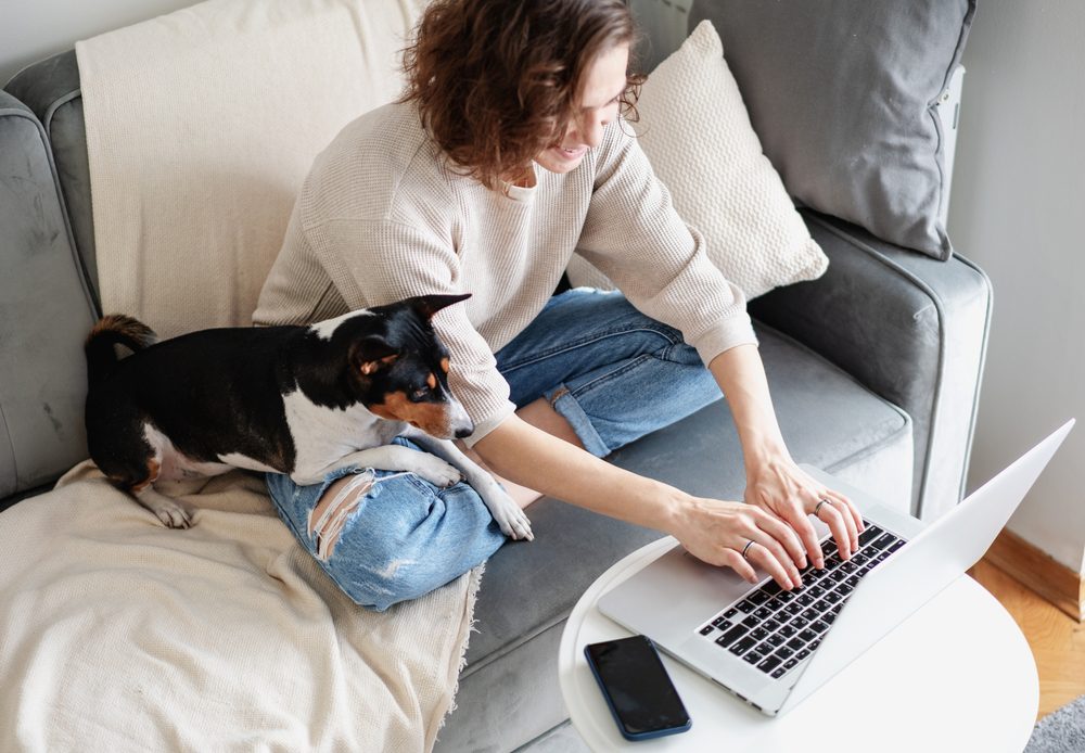 woman working on laptop with dog